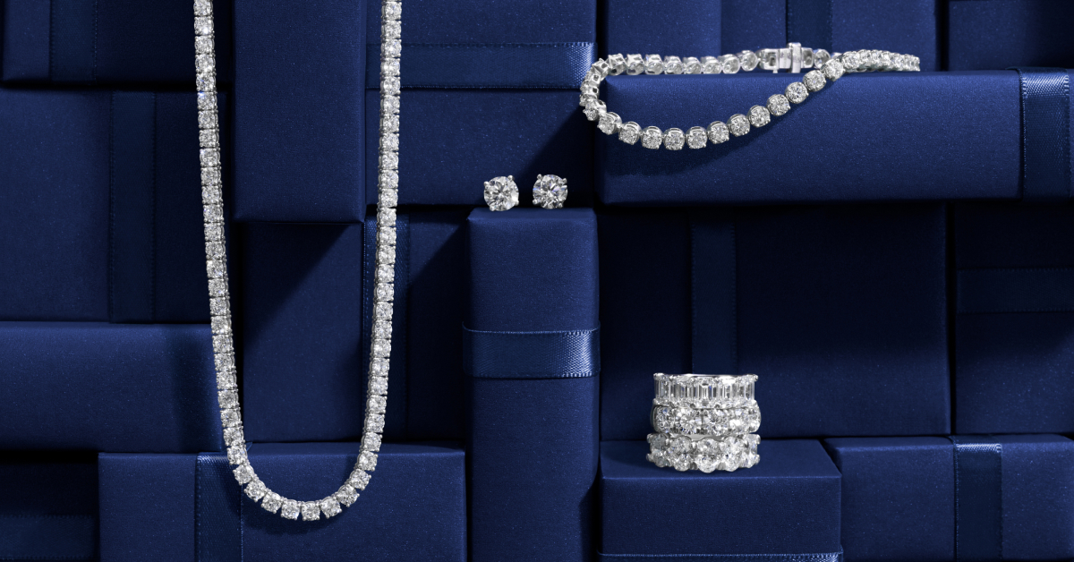 Diamond earrings, rings, necklace and bracelet on blue boxes